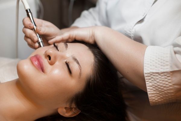 Microneedling pen being used on a client’s forehead