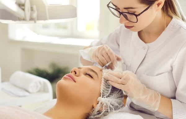 Aesthetic nurse preparing a client for a PRP facial